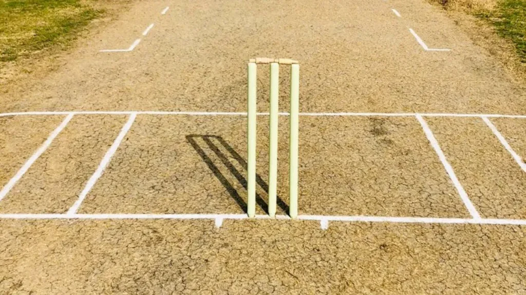 Cricket pitch with stumps and crease markings for beginners learning how to play cricket