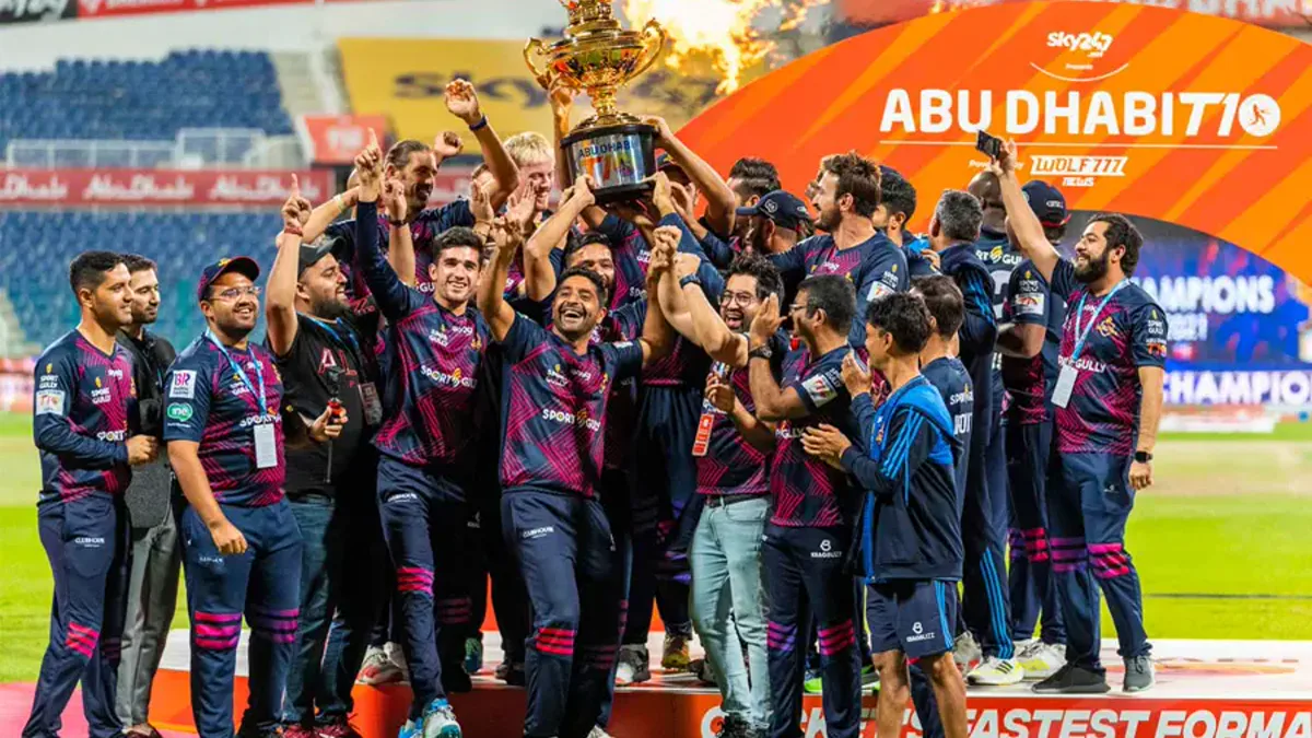Cricket players celebrating with a trophy on the field. USA League 2 Title 2026
